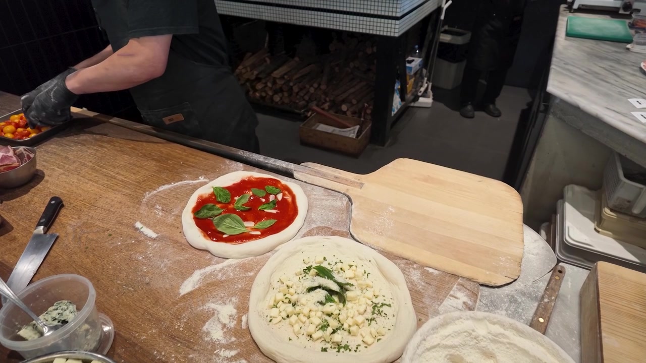 Koch bereitet frische Pizza in einer professionellen Restaurantküche zu