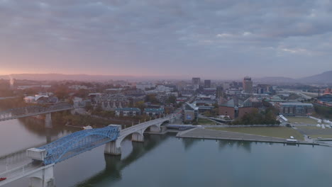 Breite-Luftaufnahmen,-Die-Sich-Während-Des-Sonnenaufgangs-Um-Die-Market-Street-Bridge-In-Der-Innenstadt-Von-Chattanooga-Drehen