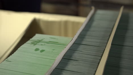 trabajador apilando elementos de vidrio terminados en una caja de cartón