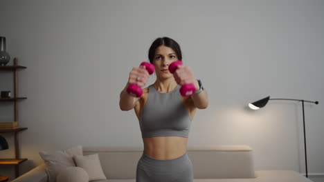 woman working out at home with dumbbells