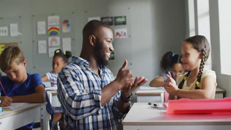 video of happy african american teacher learning caucasian girl how to count in classroom