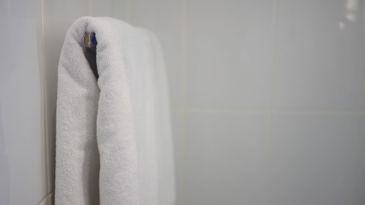 Weißes Handtuch hängt an einem Handtuchhalter im Badezimmer