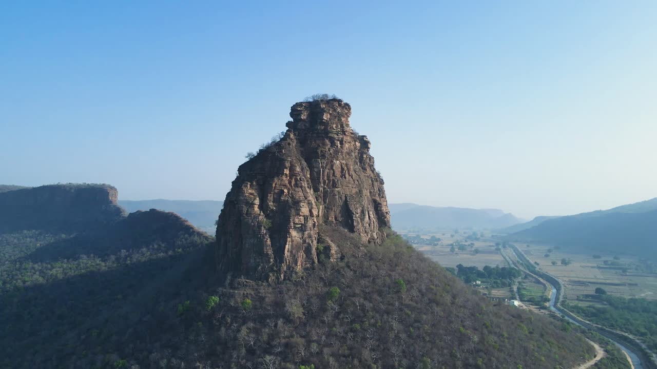 impresionante captura aérea de la presa de karamchat, rodeada de exuberantes campos verdes y colinas.