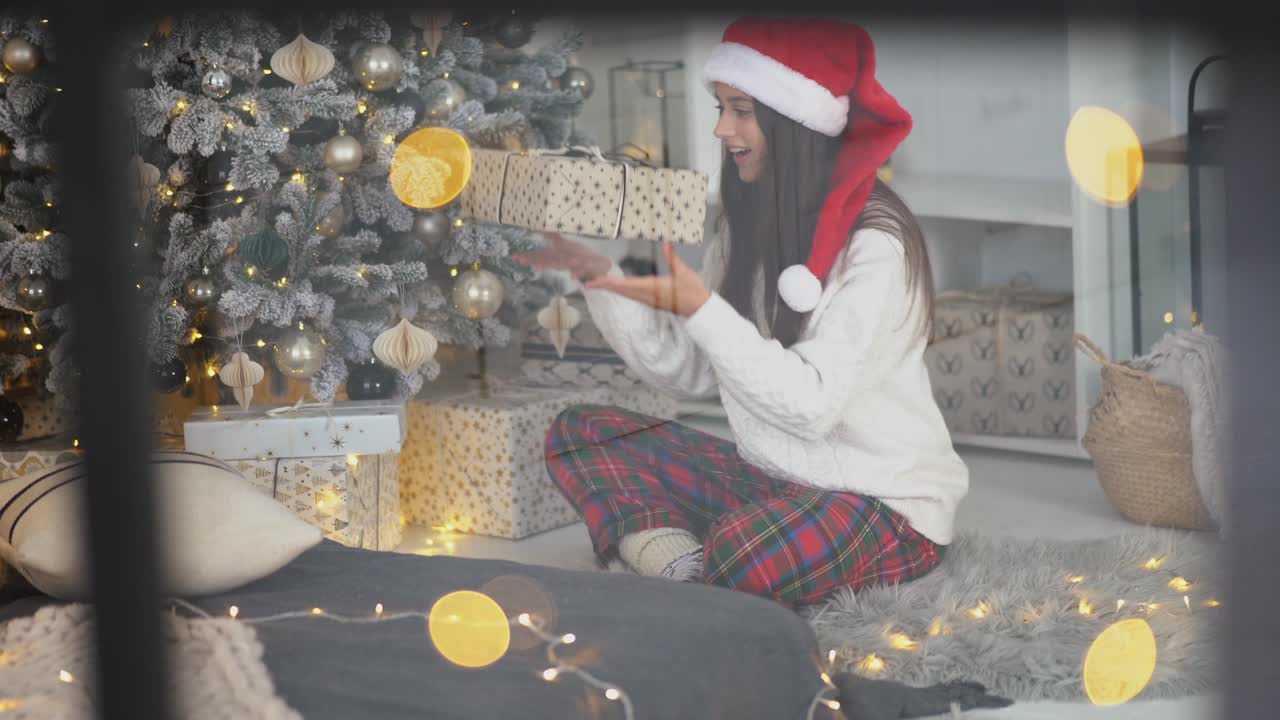 mujer abriendo el regalo de navidad junto al árbol de navidad