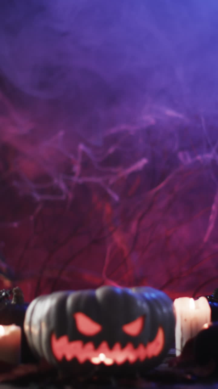 Vertical video of halloween carved pumpkin and smoke with copy space on blue background