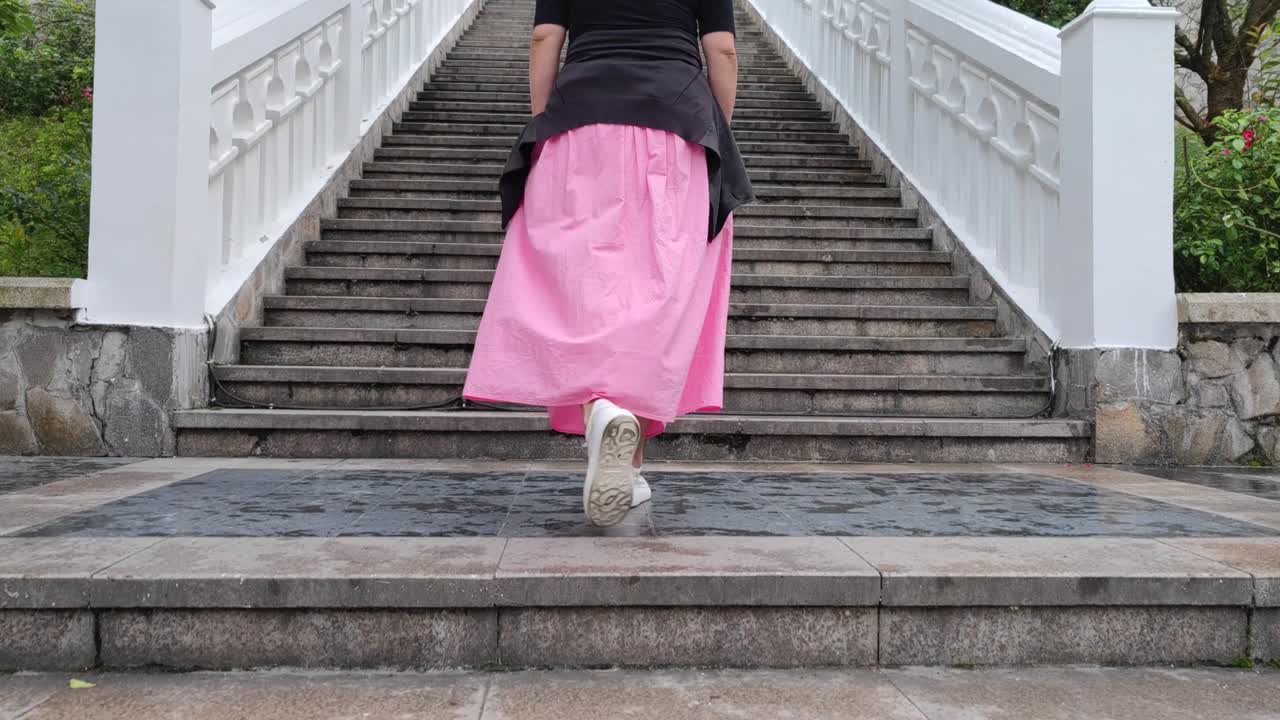 한 아시아 여성이 계단을 고 있었다.