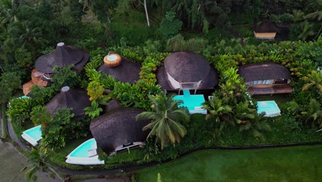 drone view of luxury bamboo villas with private pools nestled in the tropical landscapes of bali surrounded by lush greenery and designed for a peaceful and elegant escape.