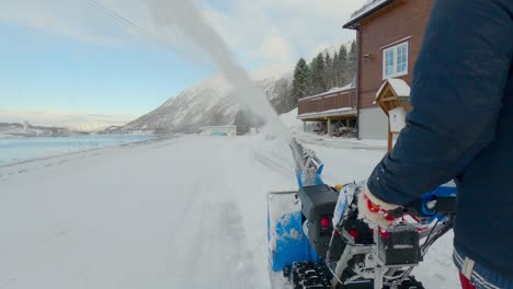 man struggling removing snow with a snow blower during the winter in northern europe