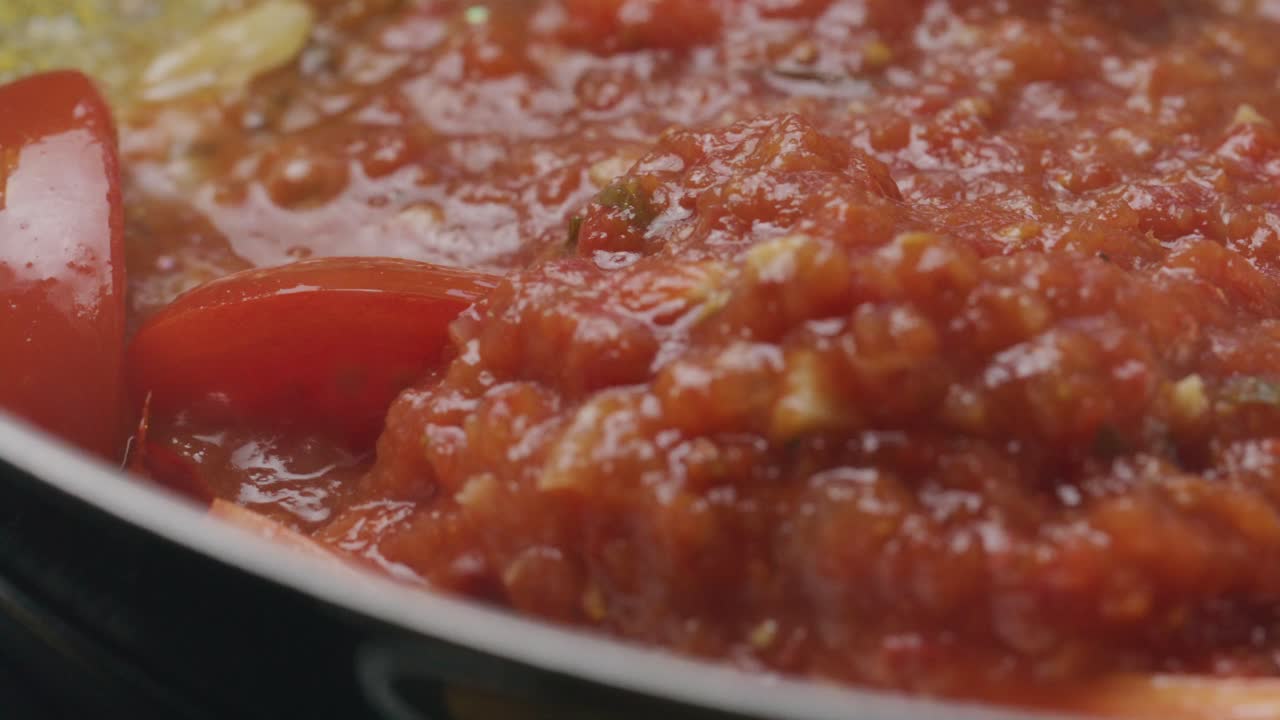 Cooking Tomato Sauce with Tomato Slices and Garlic in Frying Pan