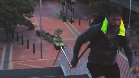 man running up stairs in city at dusk