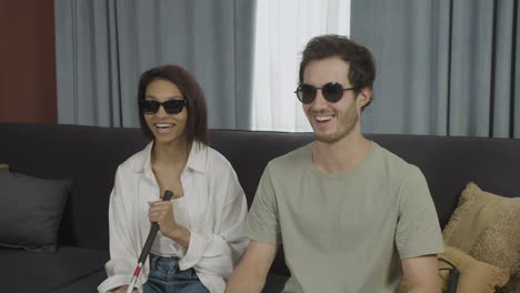 close up view of blind friends sitting on a sofa in a flat