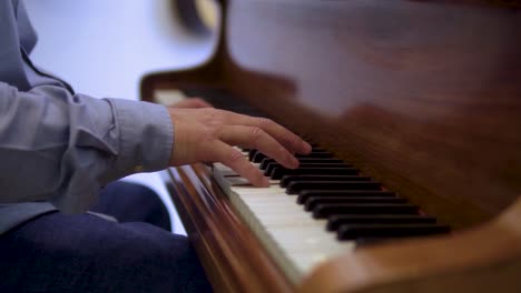 Pianist-is-performing-on-vintage-brown-wooden-piano-close-up-of-hands-playing-notes-creating-melody-cinematic