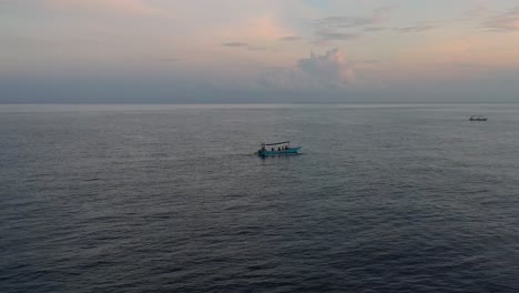 Paisaje-Aéreo-De-Un-Barco-Indonesio-Navegando-En-Un-Océano-Plano-Y-Tranquilo-Con-Turistas-Al-Amanecer-En-Lovina-Bali-Indonesia