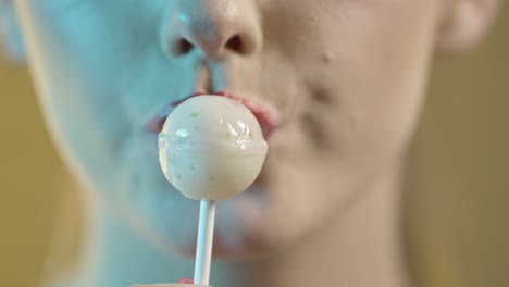 woman licking popsicle, mouth close-up shot on yellow background