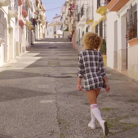 menina caminha pela rua mediterrânea ao longo