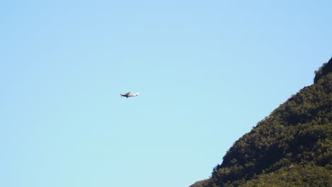 新西蘭米爾福德海峡的藍天和峡湾懸崖上的輕型飛機