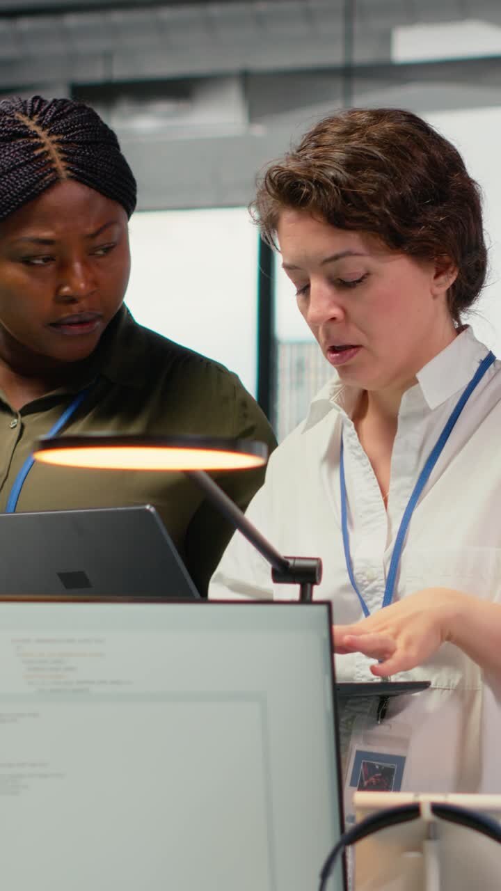 Vertical video Female engineers in startup office using AI technology driving market innovation