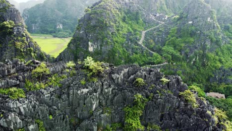 drone reveal shot of hang mua mountain in ninh binh, sharp limestone cliffs in vietnam