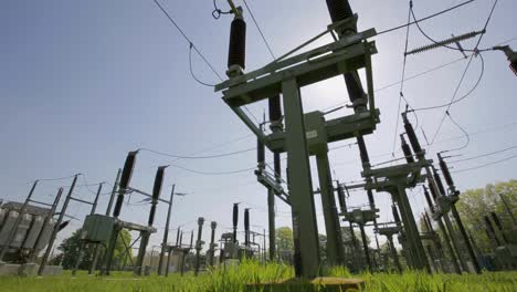 sunlit electric substation with technician inspecting the site in a grassy field, showcasing industrial equipment and safety