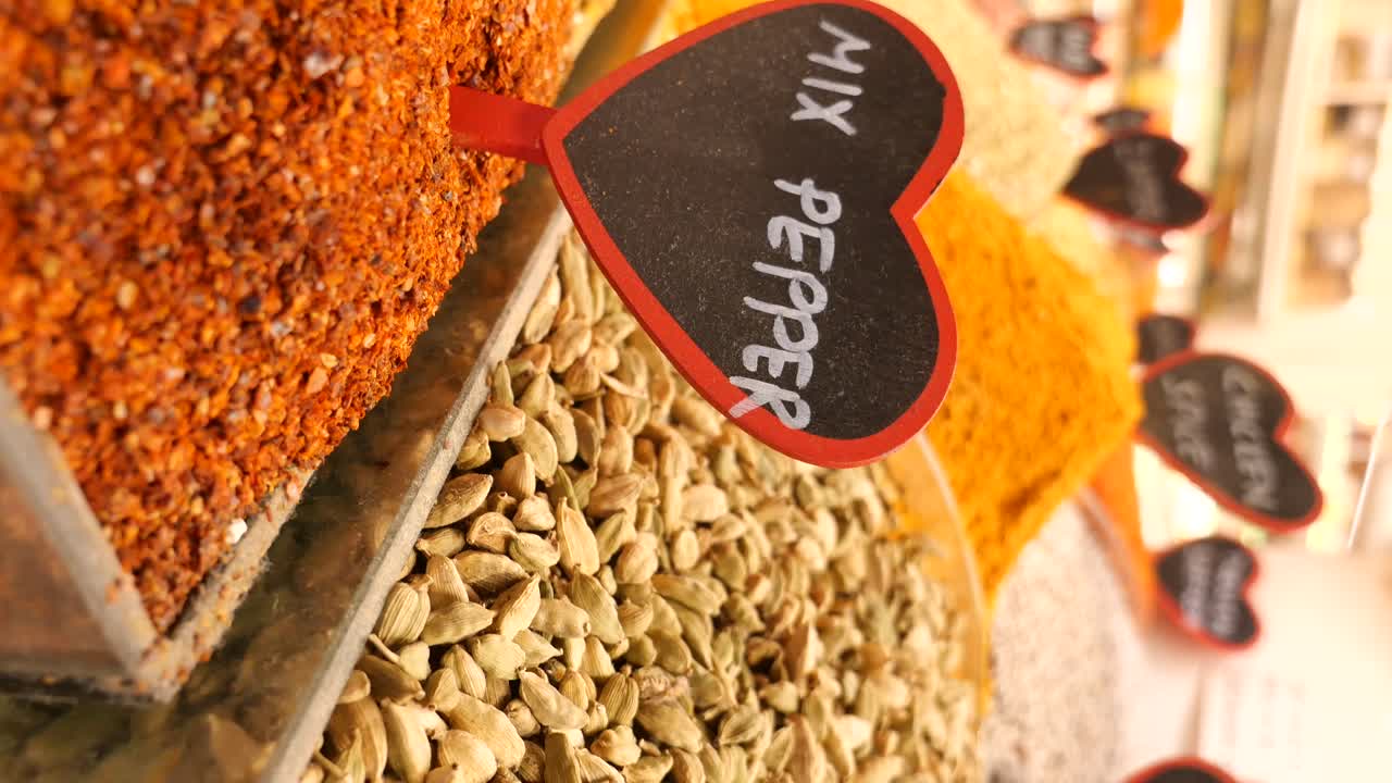 Close-up of assorted spices in a market with a 'Mix Pepper' sign