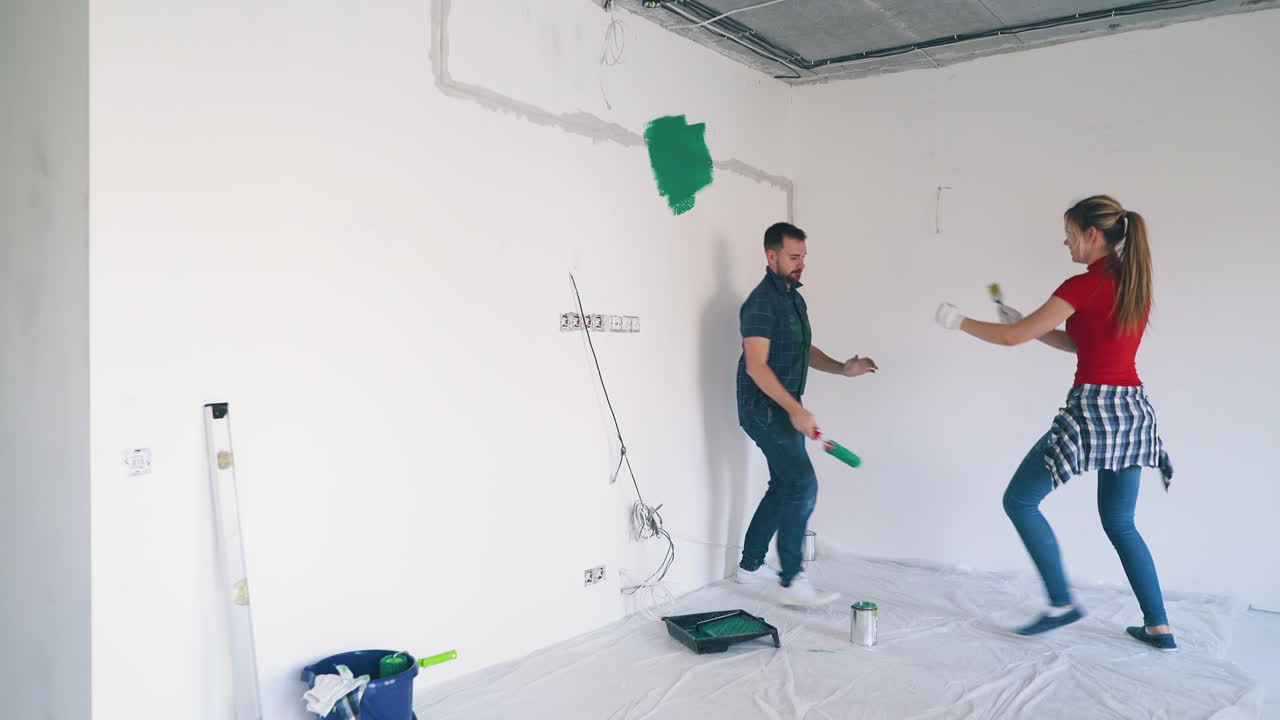 chica rubia y chico pelean pintándose el uno al otro en la habitación