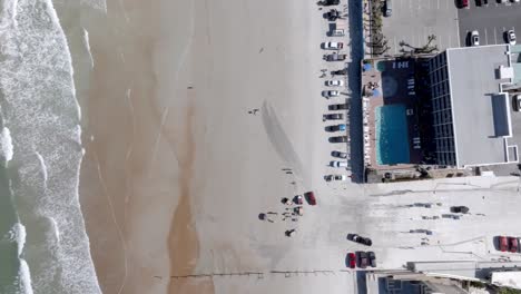 daytona beach, florida with waves from atlantic ocean and drone video overhead, looking down and stable.