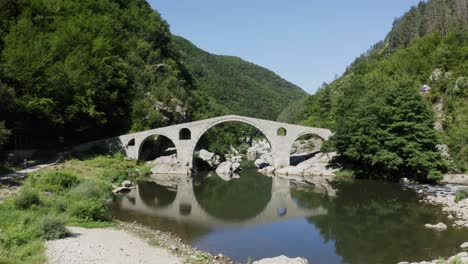 Drone-Panorámico-Desde-El-Lado-Izquierdo-Al-Derecho-Del-Marco-En-El-Puente-Del-Diablo-Ubicado-En-Ardino-Al-Pie-De-La-Montaña-Ródope-En-Bulgaria