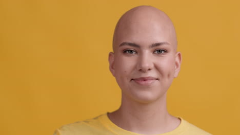 young woman with bald head making an ok sign