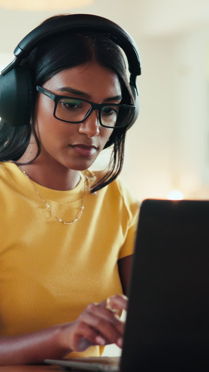 Woman working on laptop with headphones