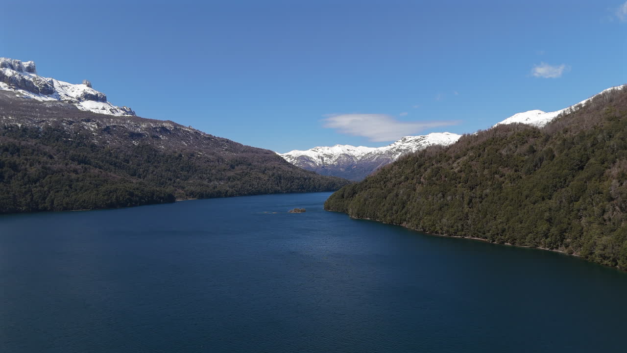 Stunning aerial view of Falkner Lake surrounded by snow-capped Andes mountain range, Neuquén, Argentina