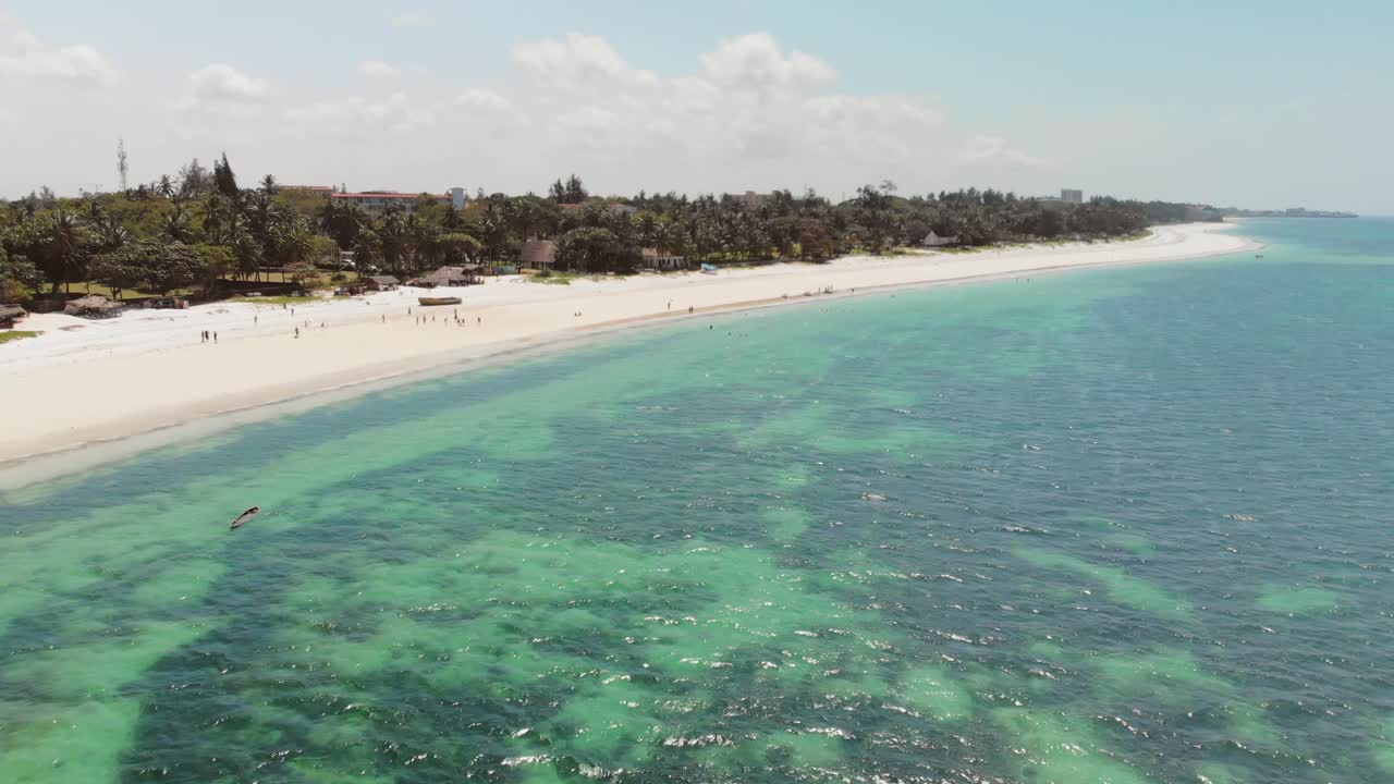 Bãi biển Mombasa vào lúc hoàng hôn nhiều mây, với các khu nghỉ dưỡng ở phía sau.
