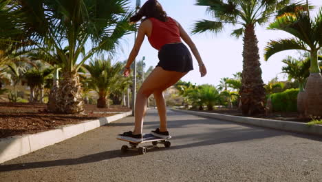 riding her skateboard with a grin, a woman enjoys the sunset while traversing the path through the park, surrounded by palm trees and sand. a joyful embodiment of a healthy life