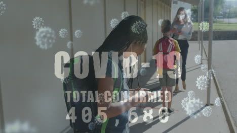 texto de covid-19 con un aumento de los casos contra los escolares que usan máscaras faciales usando teléfonos inteligentes