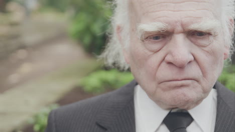 Sad-old-man-sitting-on-bench,-close-up