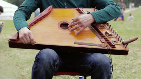 músico folclórico tocando el gusli