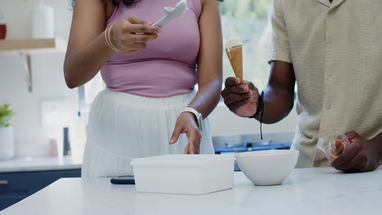 Mangfoldigt par, der øser is op fra bøtten, kvinde i lilla top fylder vaffel og forbereder snack