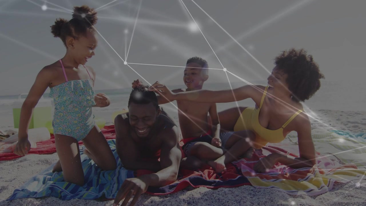 Family playing on beach, kids tugging dad's hair causing laughter for ads with faint node overlay