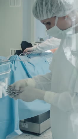 la enfermera ayuda suministrando herramientas quirúrgicas. el trabajador proporciona al cirujano los instrumentos necesarios para facilitar el procedimiento de derivación de la arteria coronaria en la sala de operaciones