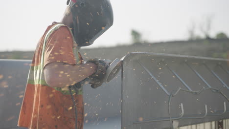 Slow-Motion-of-Safety-Clad-Worker-Smoothing-Metal-with-Circular-Saw-Outdoors