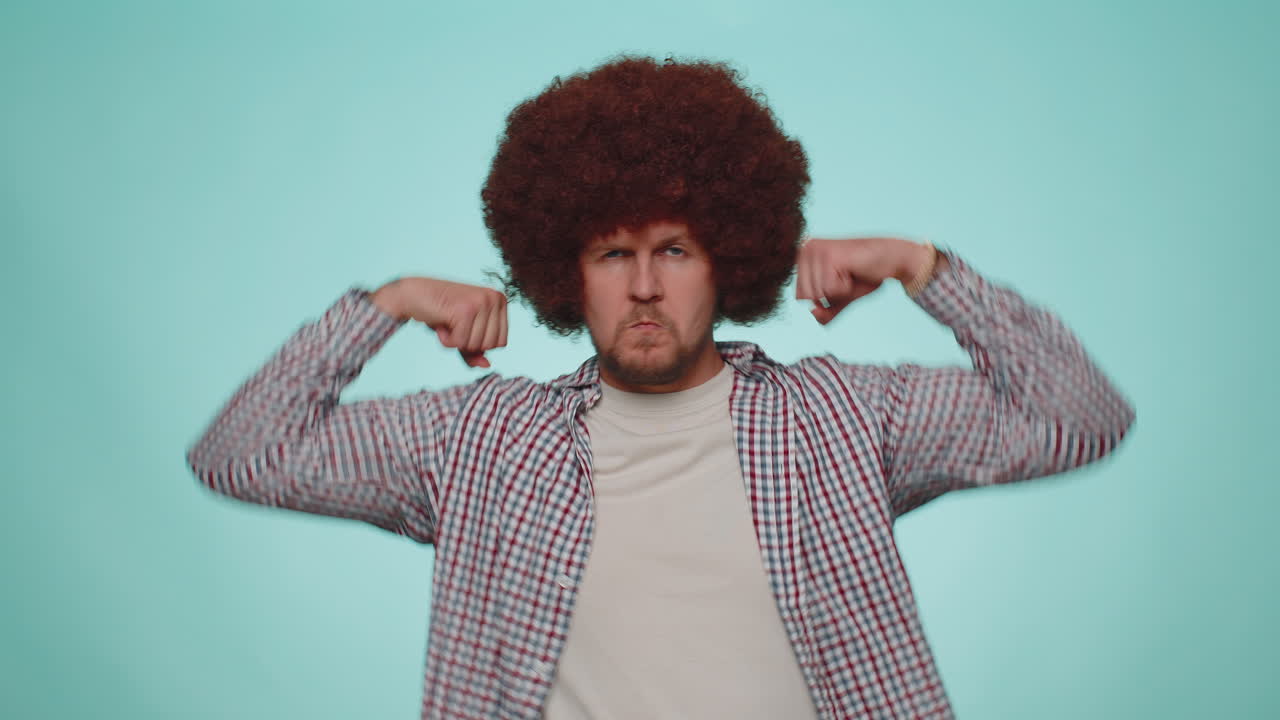 hombre mostrando bíceps y pareciendo confiado, sintiendo poder fuerza para luchar por los derechos, el éxito ganar