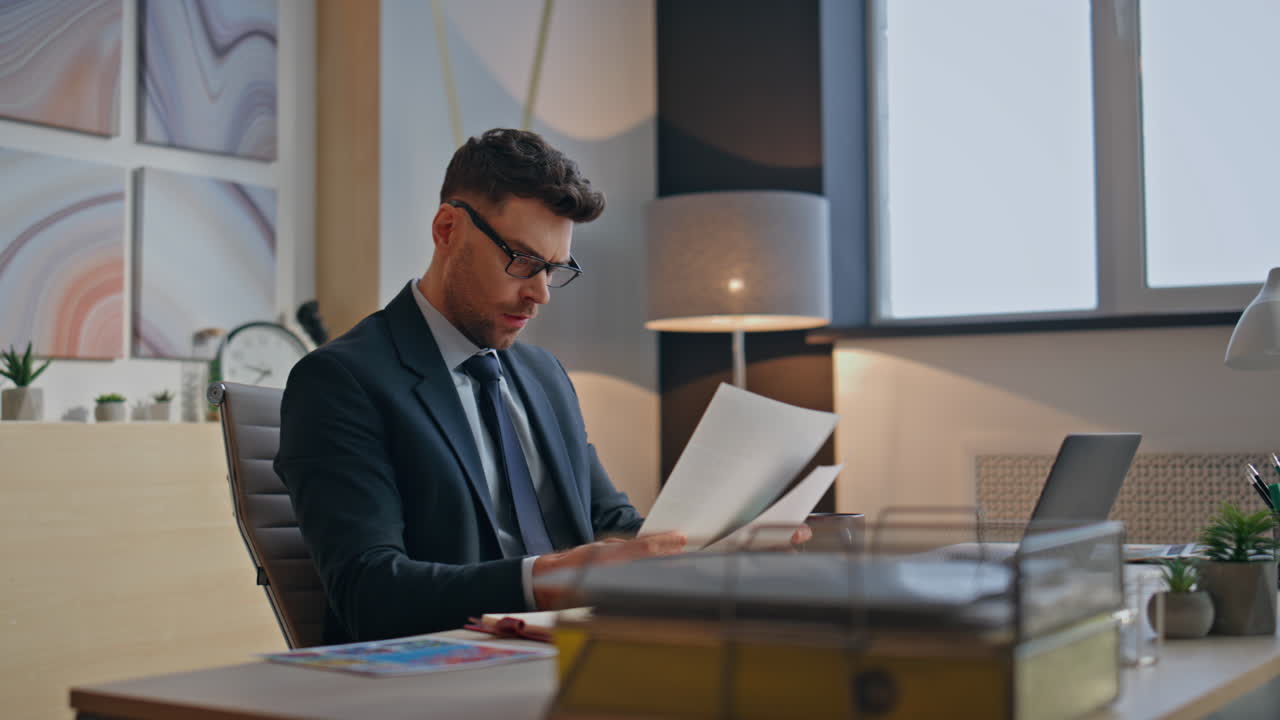 Chief designer examining documents at modern workspace closeup. Guy working