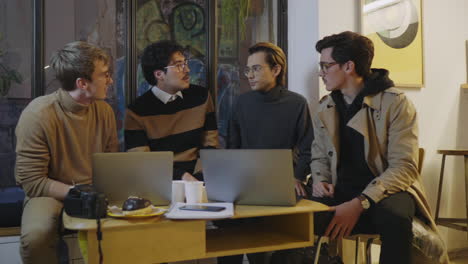 Businessman-talking-on-phone-at-cafe.Entrepreneur-talking-with-coworkers-indoors