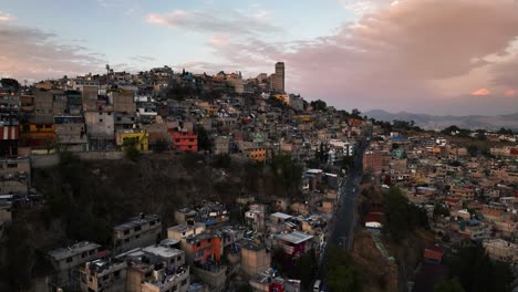 Ascending-aerial-view-of-poor-homes-and-streets-in-the-mountains-of-Naucalpan,-sunset-in-Mexico