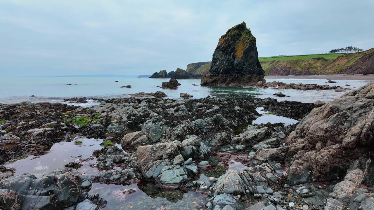 Timelapse episke steder Irland indkommende tidevand ved Ballydwane strand Waterford Irland med klippebassiner og havstakke fantastisk irsk kyst
