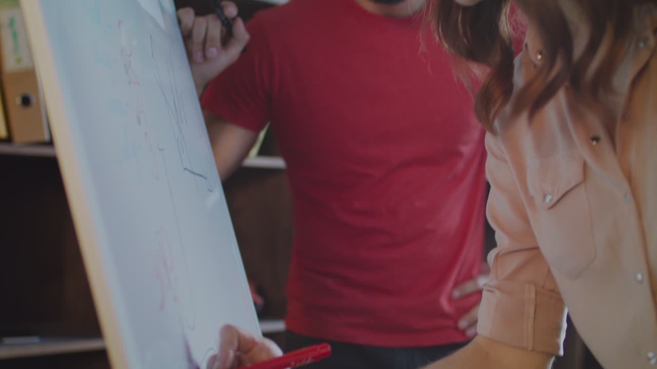 primer plano de una mujer de negocios dibujando a mano un gráfico en una pizarra en la oficina