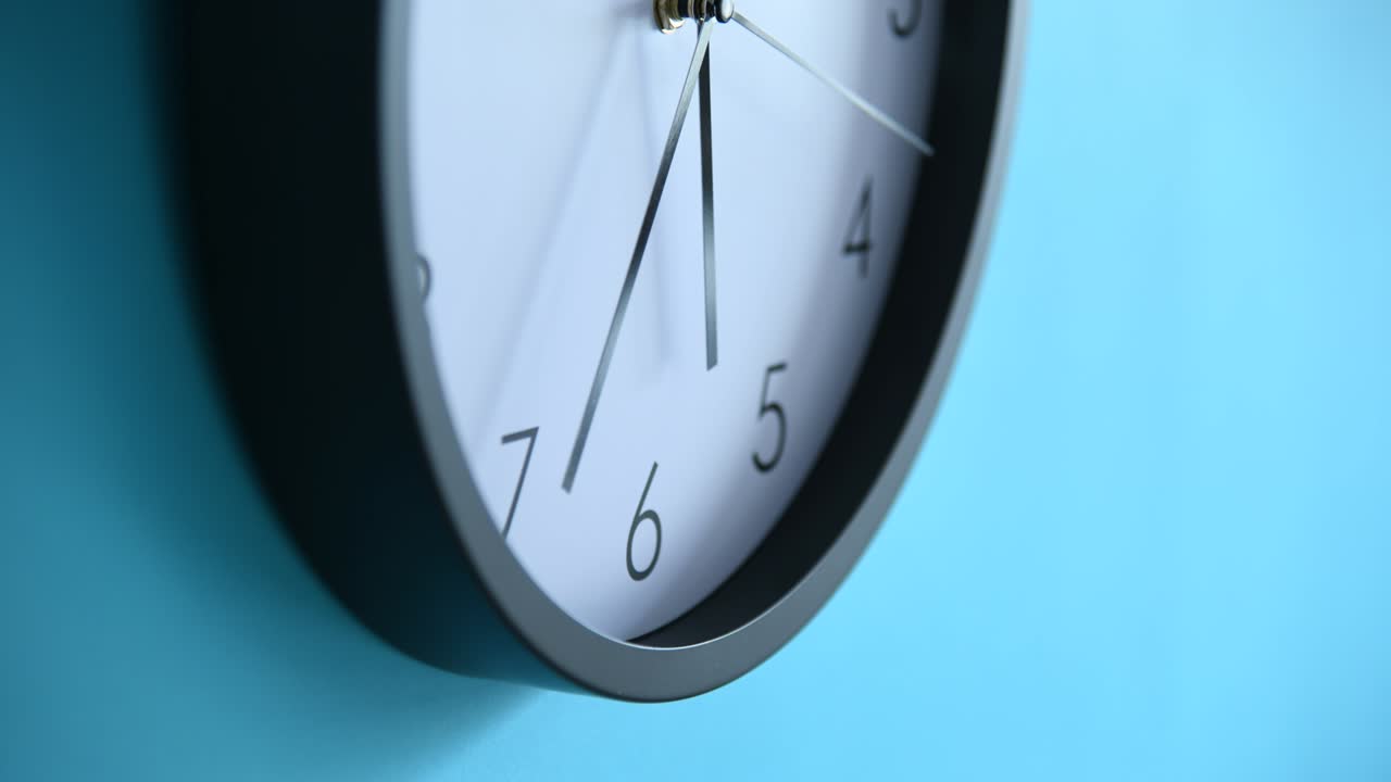 Time lapse of black clock on blue wall