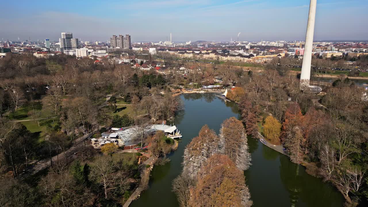 drone flight over Luisenpark in Mannheim with river Neckar and cityscape in background on a sunny day