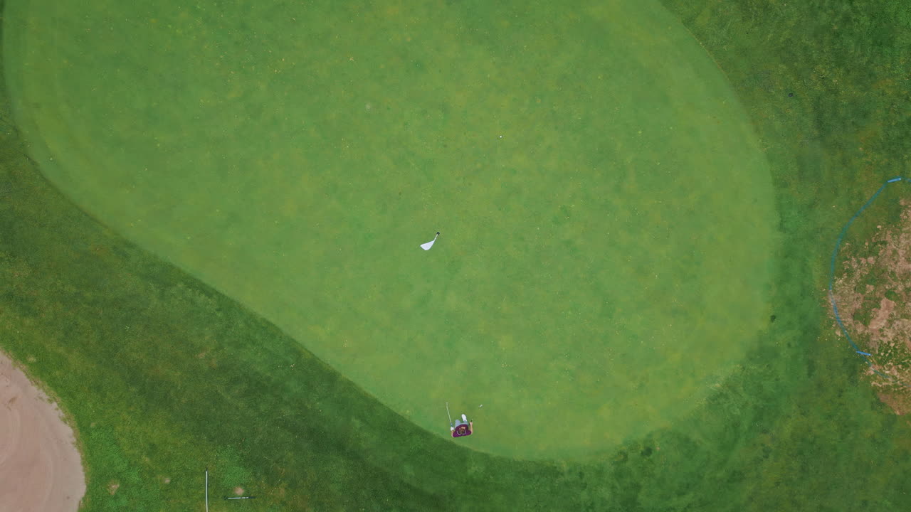Golf player playing green course poised for next swing drone view. Calm golfer
