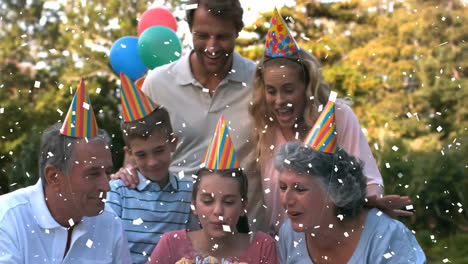 confetti animation over family celebrating birthday outdoors with cake and balloons