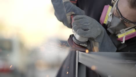 metal worker polishing metal construction corner with angle grinder